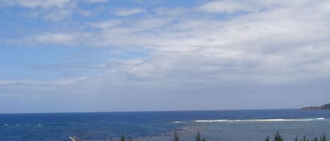 Un paisaje costero con vista al océano y una masa de tierra distante.