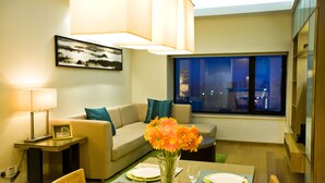A modern living room with a dining area, a sofa, a coffee table, and a city view through the window. - Somerset International Building Tianjin (Tianjin)