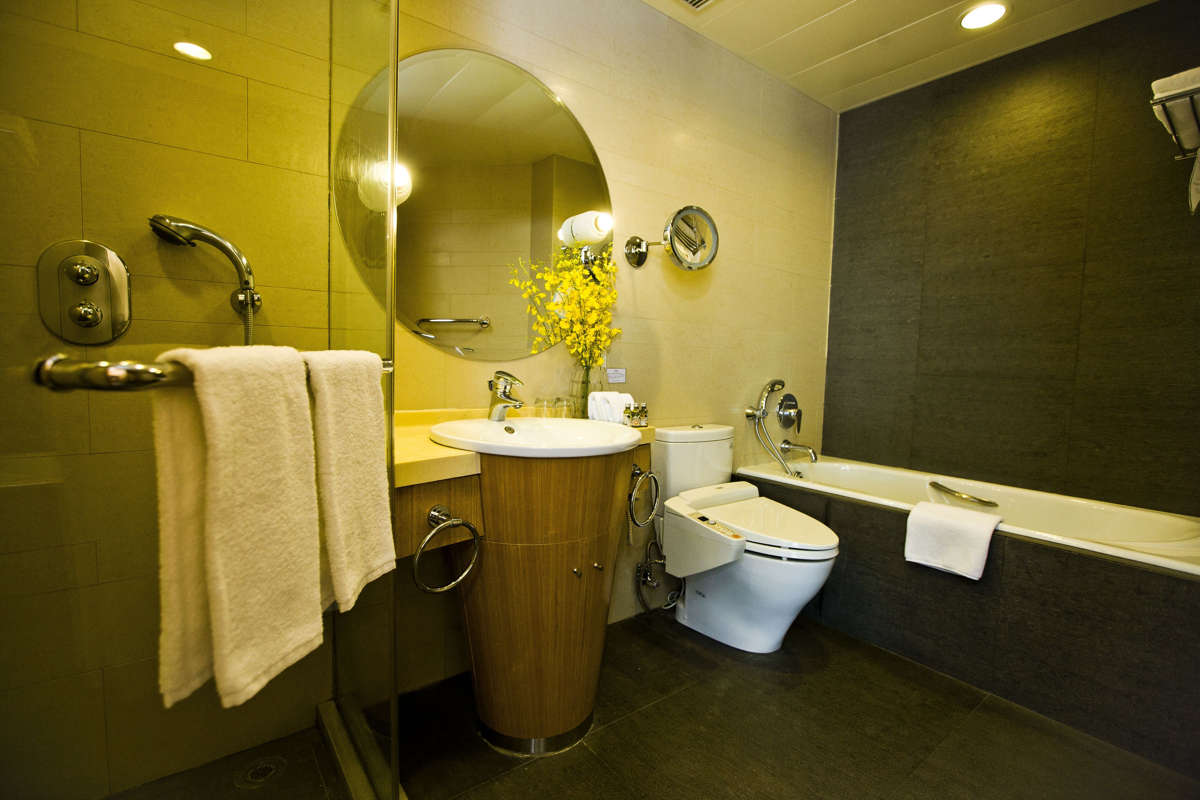 A modern bathroom with a sink, toilet, and bathtub.