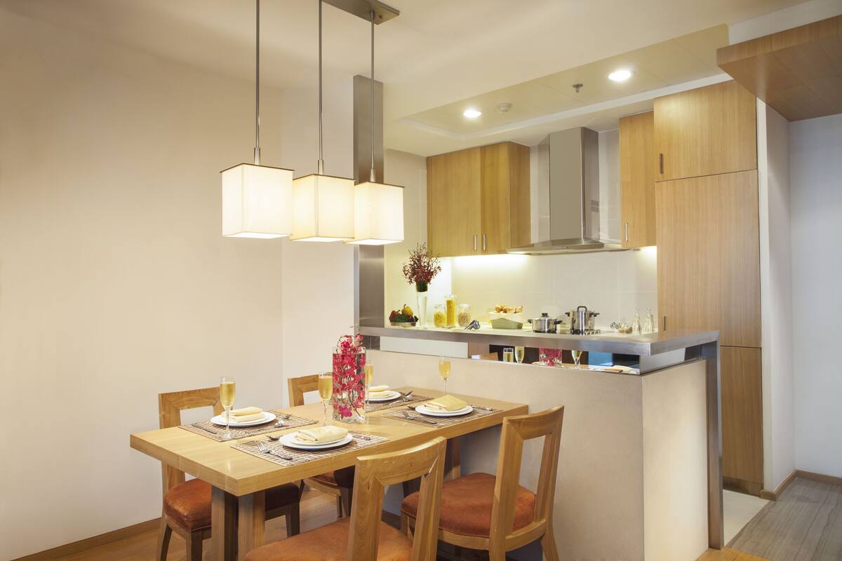 Une cuisine moderne avec des meubles en bois, un îlot central et des luminaires suspendus.