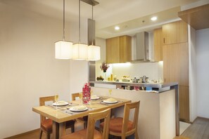 Een moderne keuken met houten kastjes, een centraal eiland en hanglampen.