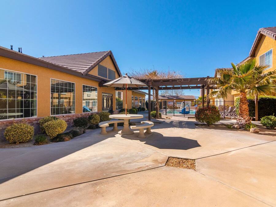 A residential area with a patio, outdoor seating, and a pool.