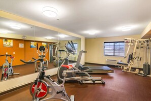 A gym with exercise equipment, a mirrored wall, and a window. - Comfort Inn & Suites Mojave (Mojave)