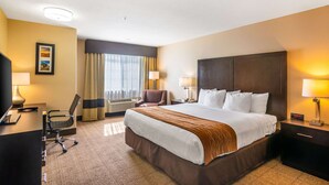 A hotel room with a large bed, a desk with a chair, a TV, and two lamps. - Comfort Inn & Suites Mojave (Mojave)