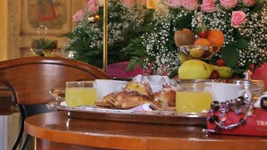 A dining table with breakfast items, a mirror, and a floral arrangement. - Alloggi Olimpia (Venice)