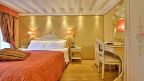 A hotel room with a large bed, bedside lamps, a desk, and a chair. - Alloggi Olimpia (Venice)