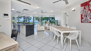 Una cucina moderna con zona pranzo, ampie finestre e vista sull'oceano.