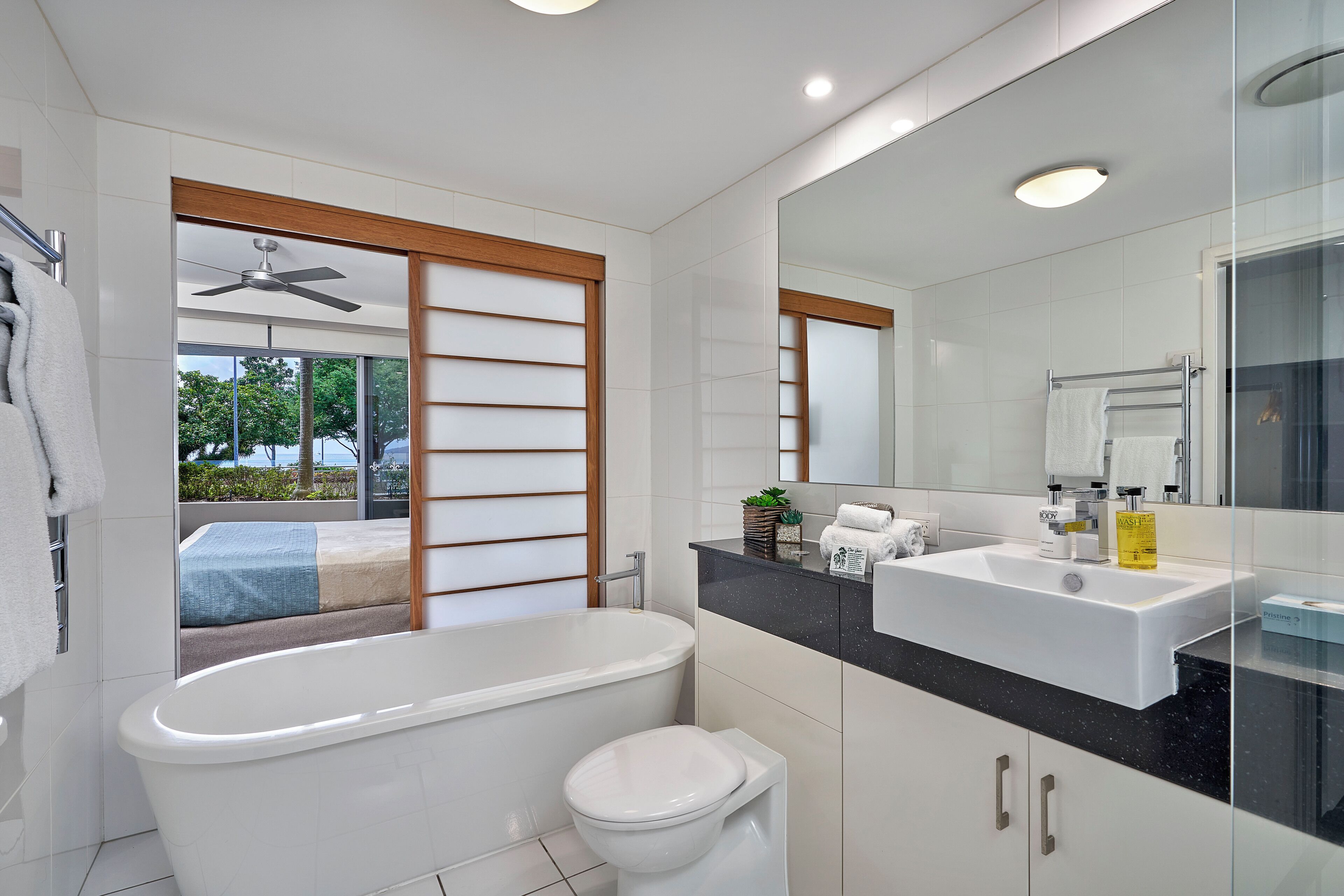 A modern bathroom with a bathtub, toilet, and sink.