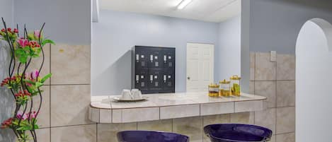 Une salle de bain avec deux lavabos violets, un miroir et un porte-serviettes.