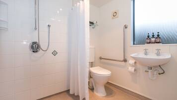 A bathroom with a shower, toilet, and sink.