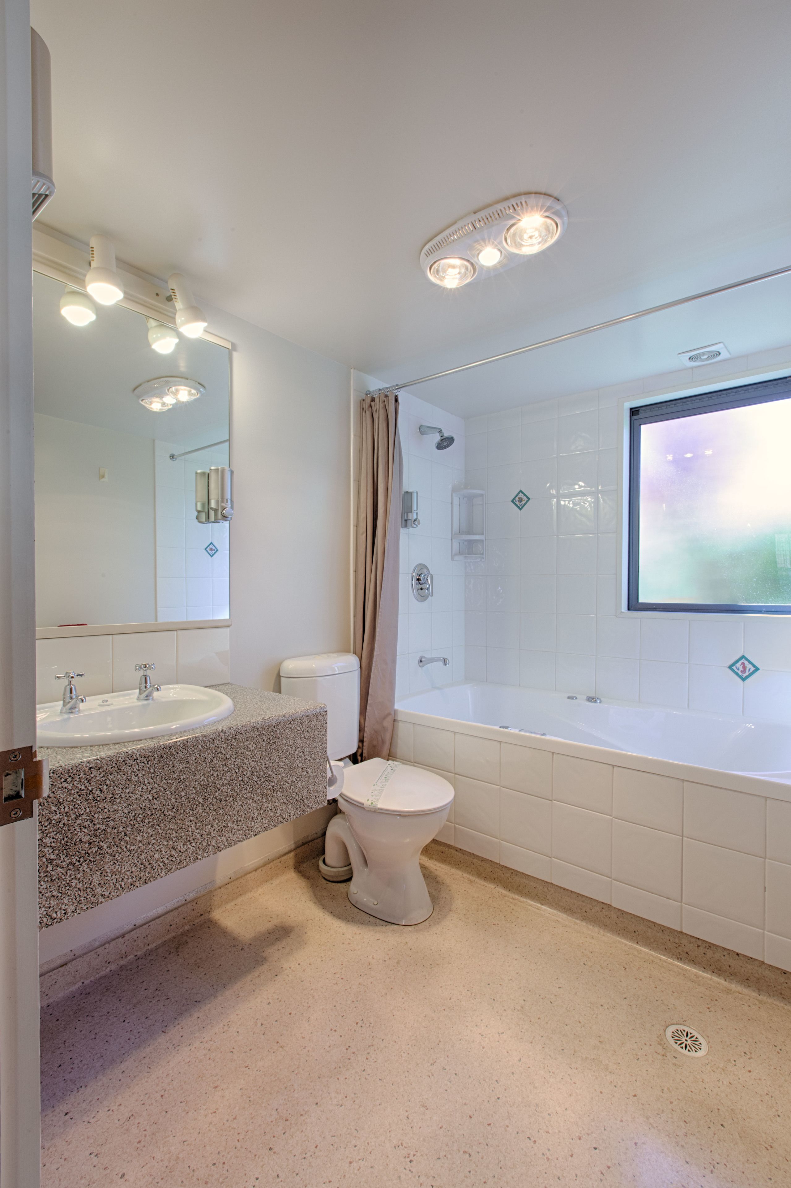 A modern bathroom with a sink, toilet, and bathtub.