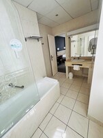 A modern bathroom with a bathtub, a sink, and a shower area.