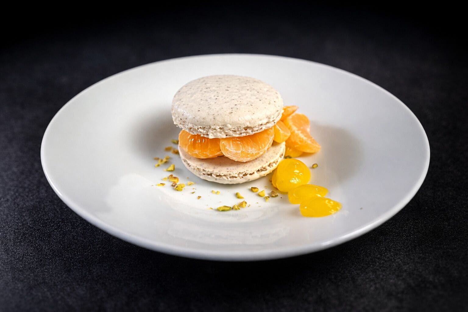 A dessert on a white plate with a dark background.