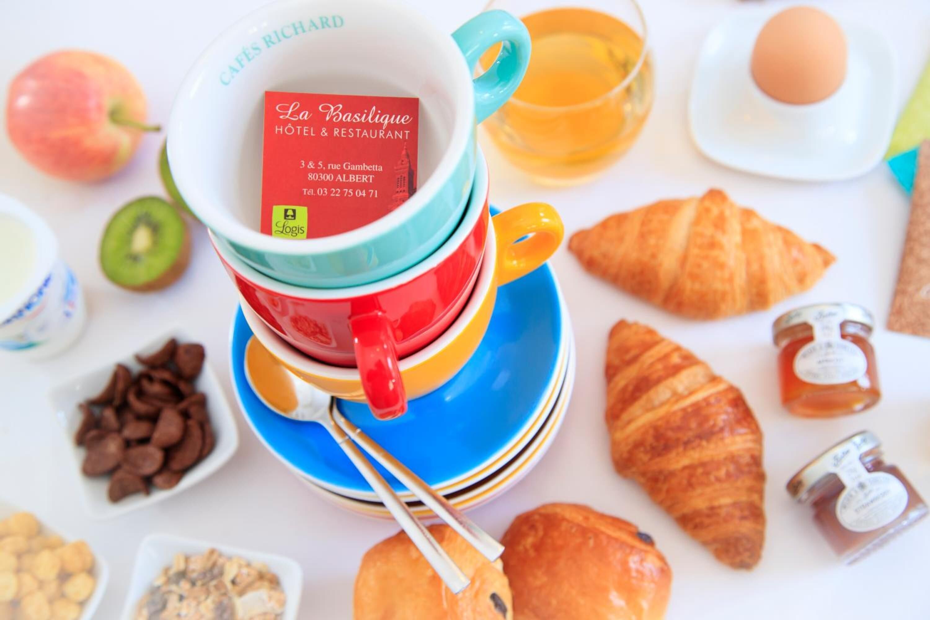 A breakfast setting with a coffee cup, croissants, and various pastries.
