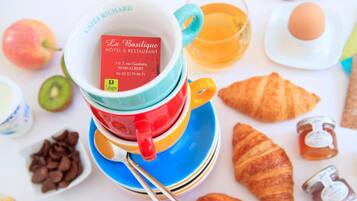A breakfast setting with a coffee cup, croissants, and various pastries.
