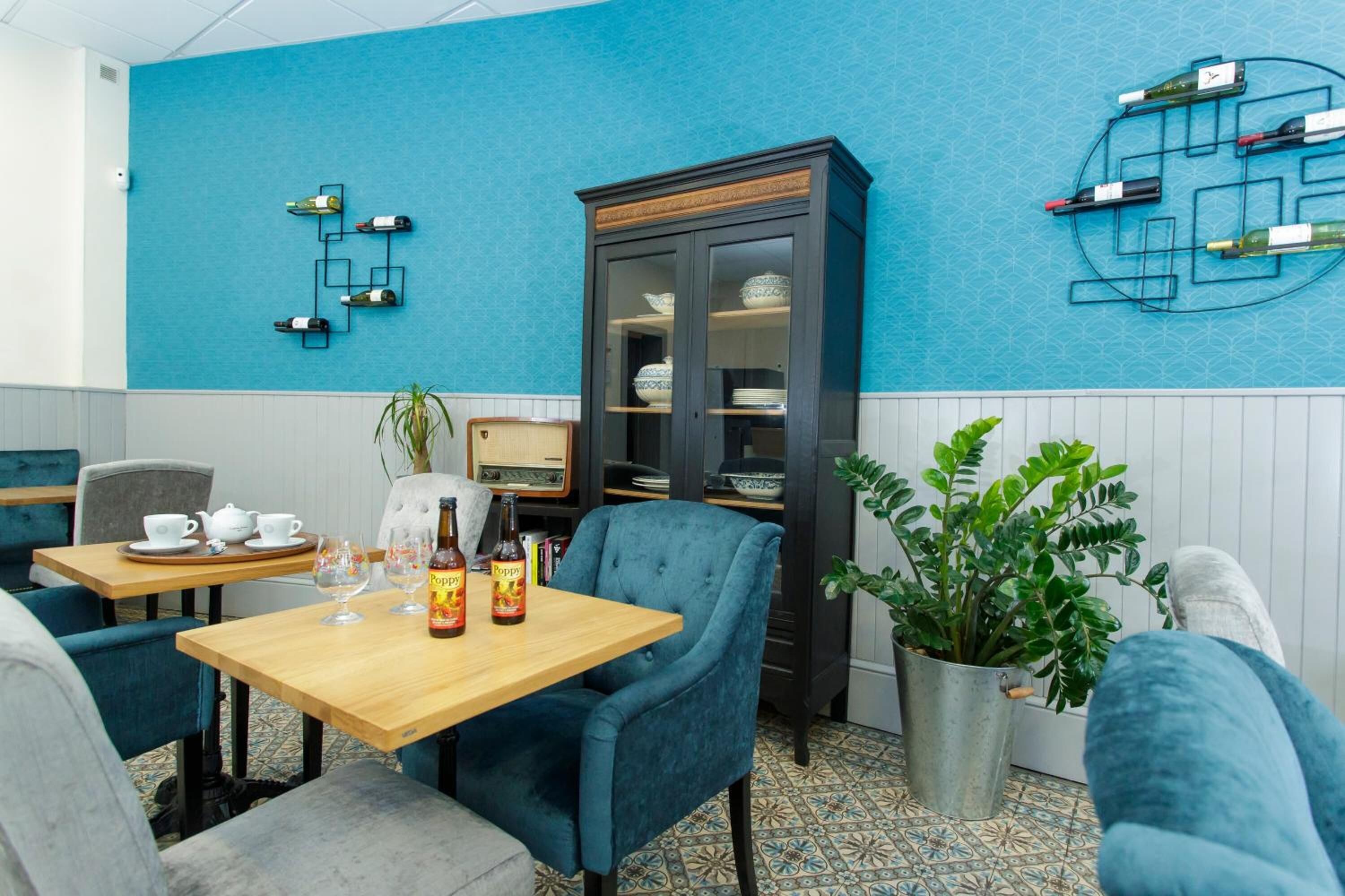 A cozy dining area with a wooden table, blue chairs, and a cabinet with glass doors.