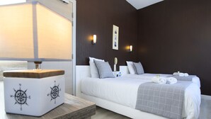 A modern hotel room with a large bed, bedside tables, a lamp, and wall-mounted lights. - Hotel & Restaurant de la Basilique (Albert)