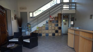 A reception area with a staircase, seating, and a reception desk.
