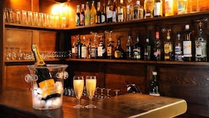 A bar area with a variety of liquor bottles and glasses.