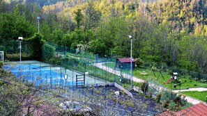 A swimming pool surrounded by a fenced area with a small building and a playground. - Antiche Terre Hotel & Relax (Pignone)