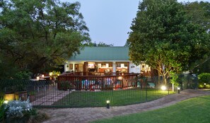 A house with a covered patio, surrounded by a fenced garden. - Rivonia Premier Lodge (Johannesburg)
