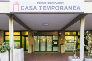 L'ingresso di un edificio con un cartello che riporta la scritta "RESIDENZE CASA TEMPORANEA".