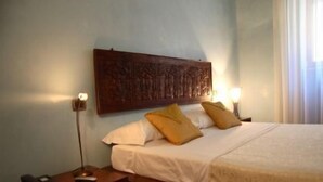 Une chambre à coucher avec une tête de lit en bois, une table de chevet avec une lampe et deux oreillers.