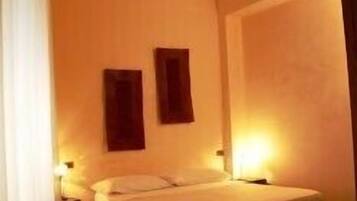 Ein Schlafzimmer mit einem Einzelbett, zwei Nachttischen und einem großen Fenster.