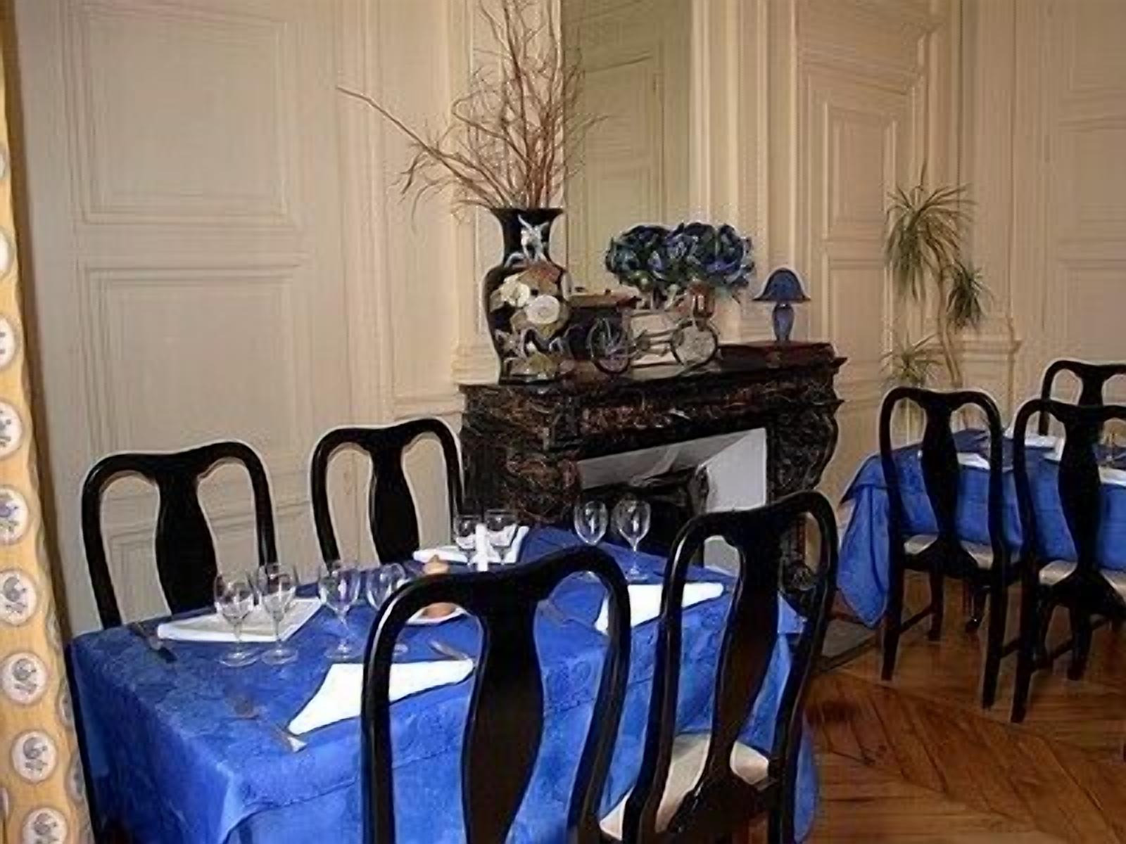 A dining area with a table set for four, surrounded by chairs.