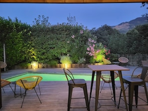 A patio area with a pool, wooden deck, and outdoor furniture. - Artemisia Boutique Hôtel (Bastelica)