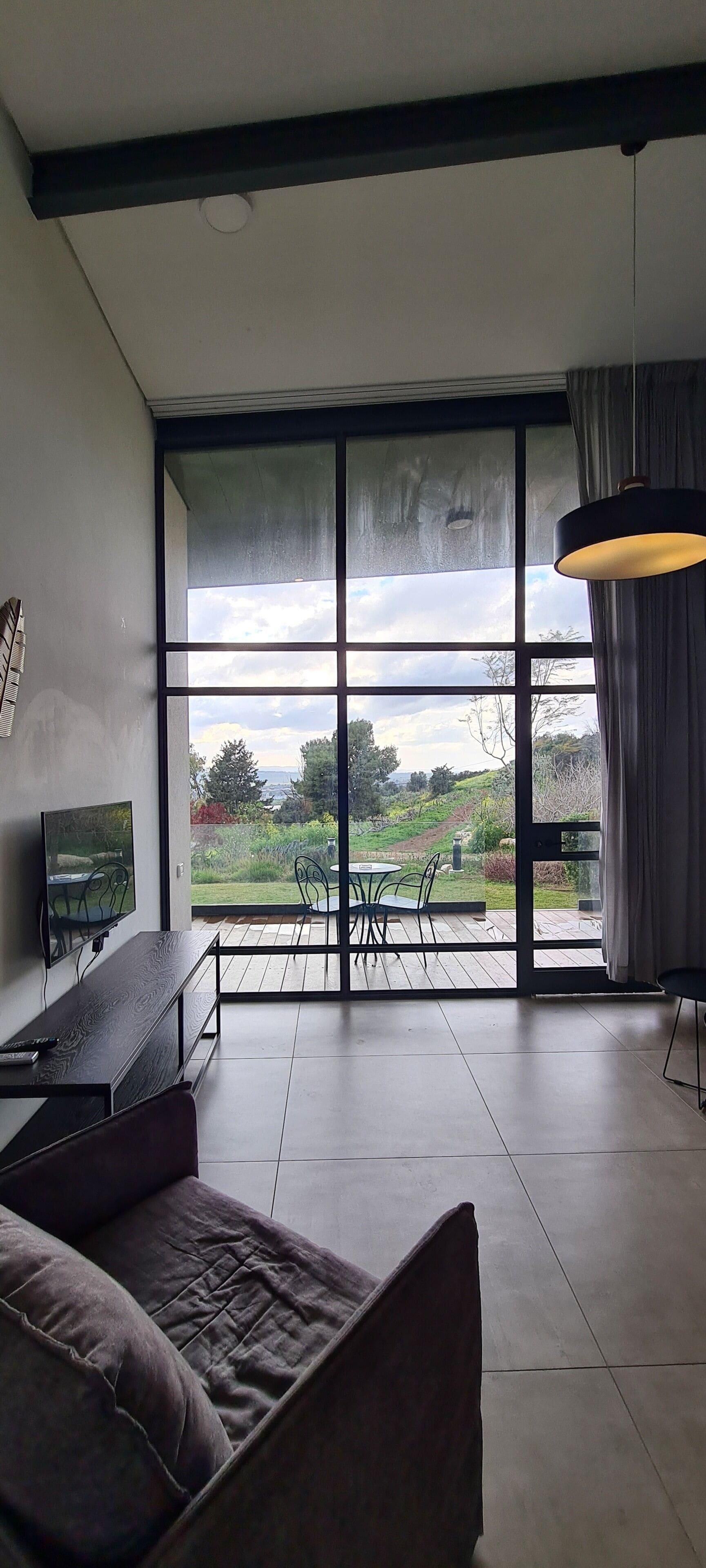Un salon moderne doté d’une grande porte-fenêtre coulissante donnant sur une terrasse.