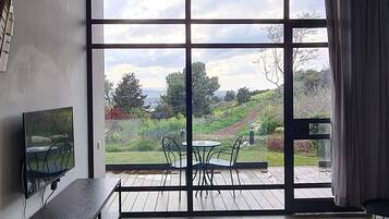 Un salon moderne doté d’une grande porte-fenêtre coulissante donnant sur une terrasse.