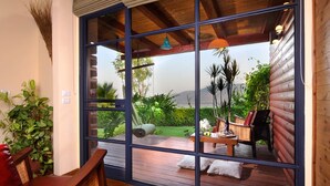 Une terrasse en bois offrant une vue sur un jardin et des montagnes.