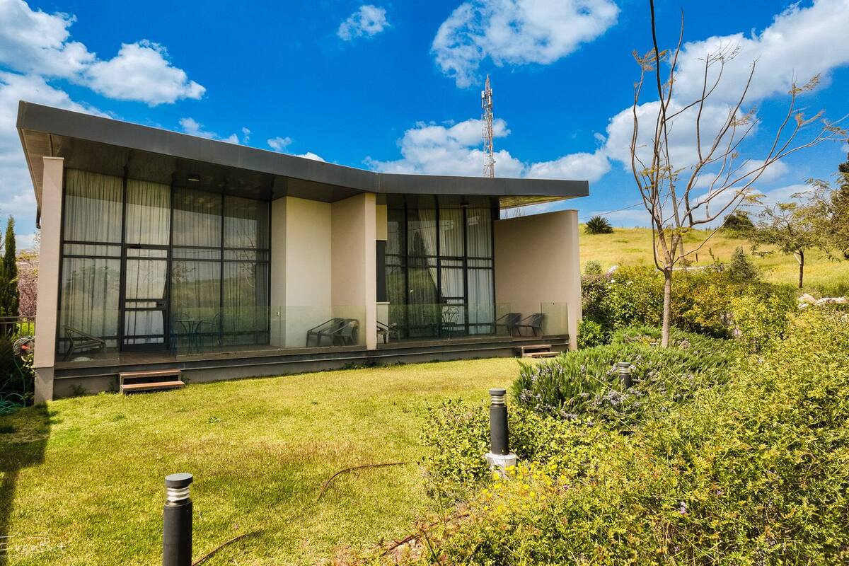 Une maison moderne dotée de grandes fenêtres et d’un porche abrité.