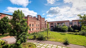 Une cour intérieure agrémentée d’un bâtiment historique, d’appartements modernes et d’une pelouse bien entretenue.