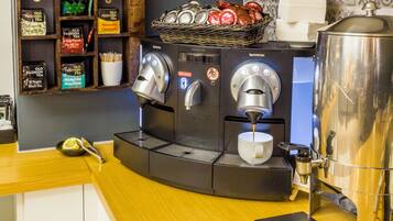 Una macchina da caffè con due erogatori e un cestino di tazze sopra.