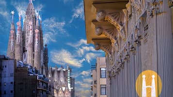 A cityscape with a prominent cathedral featuring spires and a cross, surrounded by modern buildings.