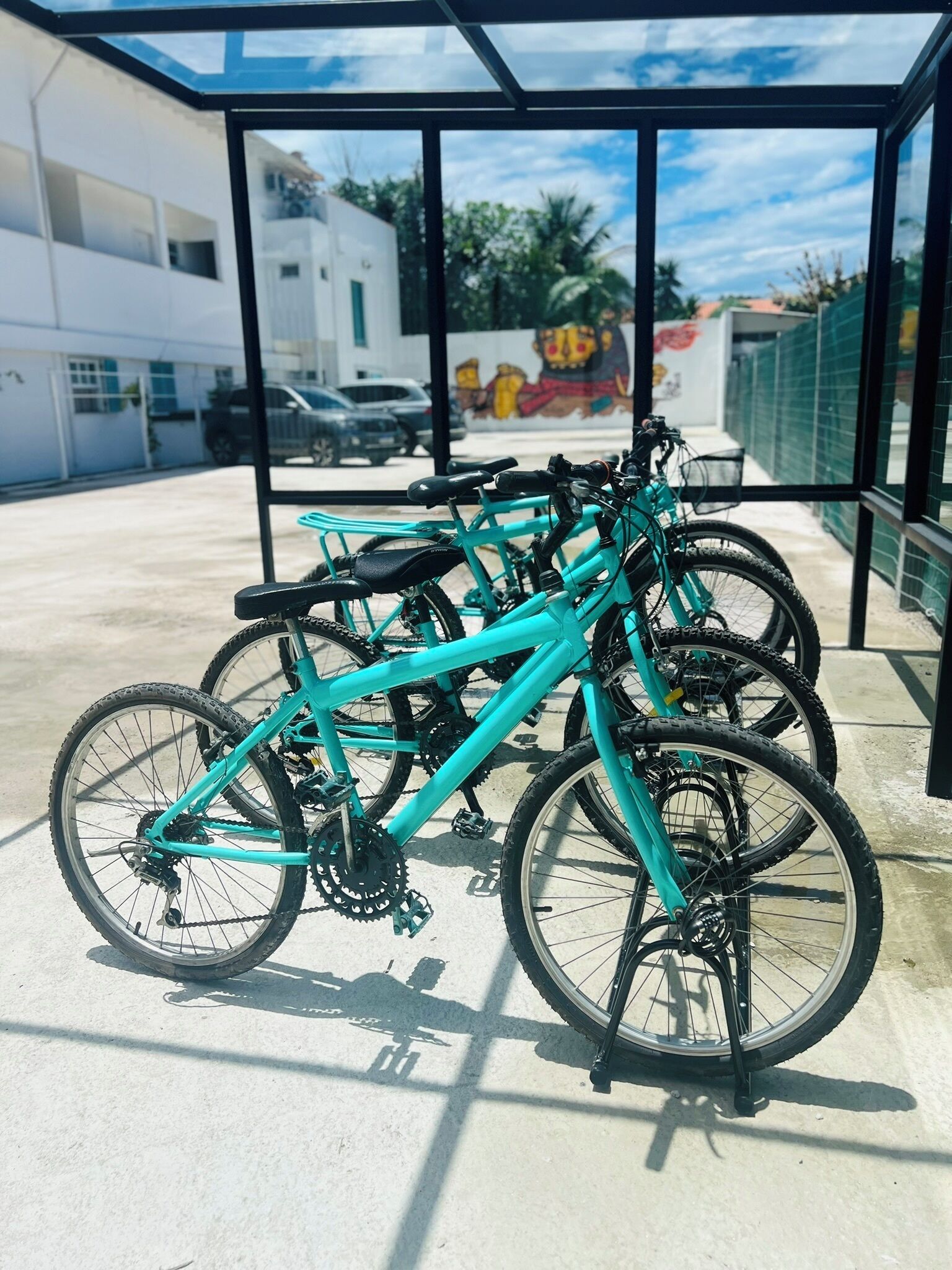 A covered bike parking area with several bicycles.