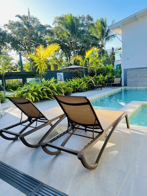 Piscine extérieure, parasols de plage, chaises longues