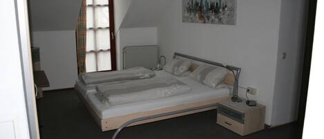 Une chambre à coucher avec un lit, une table de chevet, une lampe et un tableau au mur.