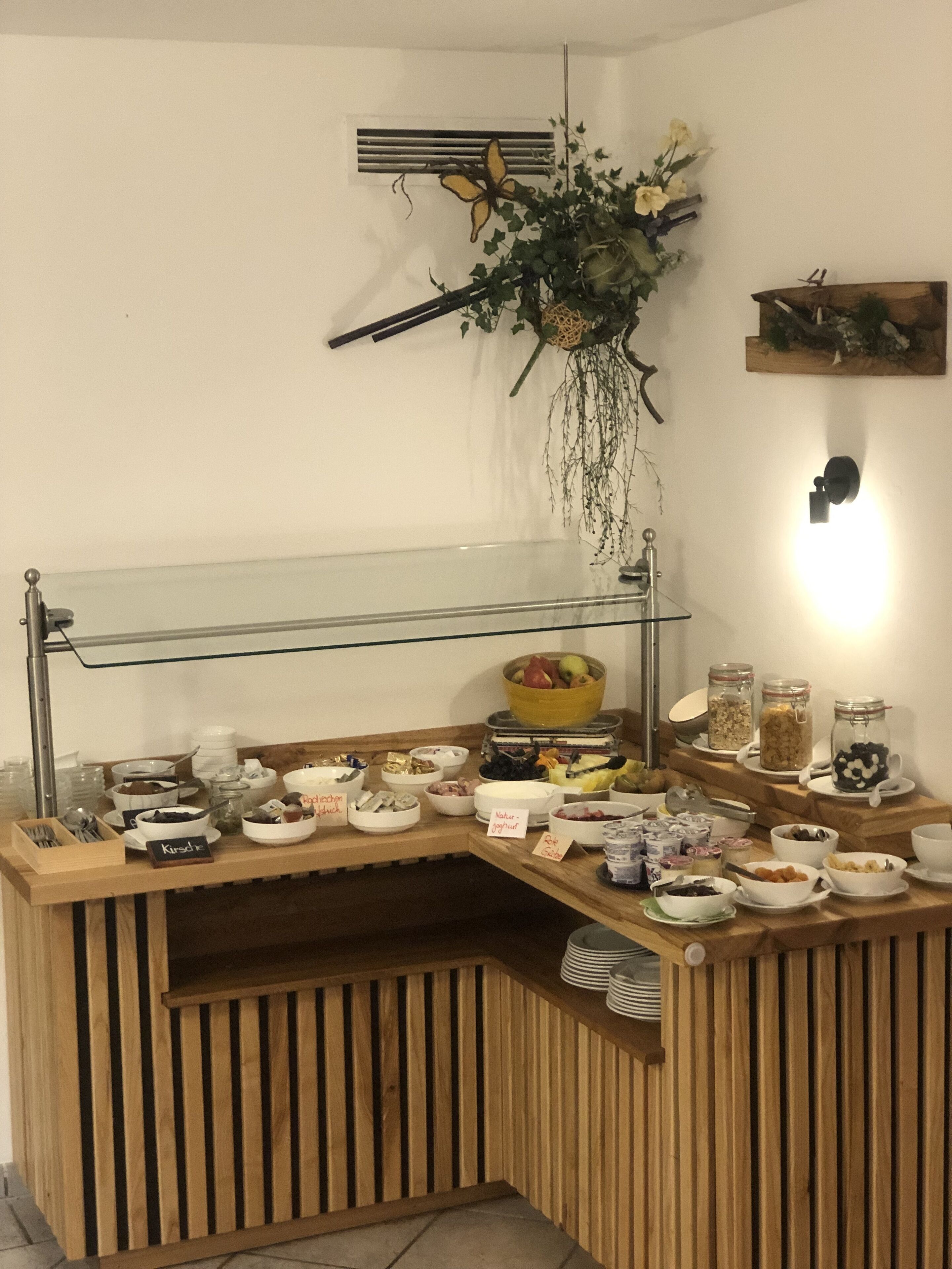 A breakfast buffet setup with various food items and utensils.