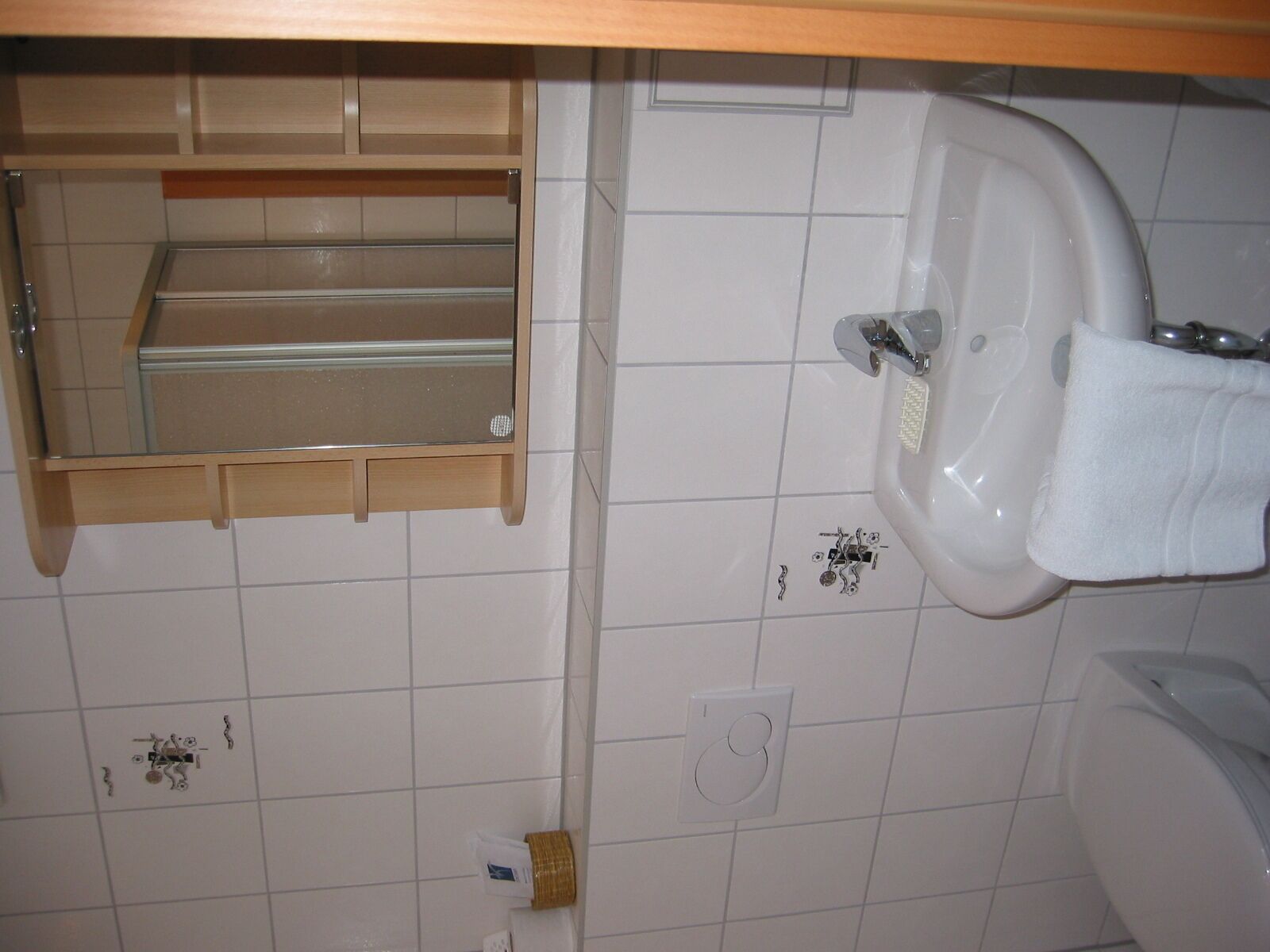 Ein Badezimmer mit Waschbecken, Spiegel und Handtuchhalter.