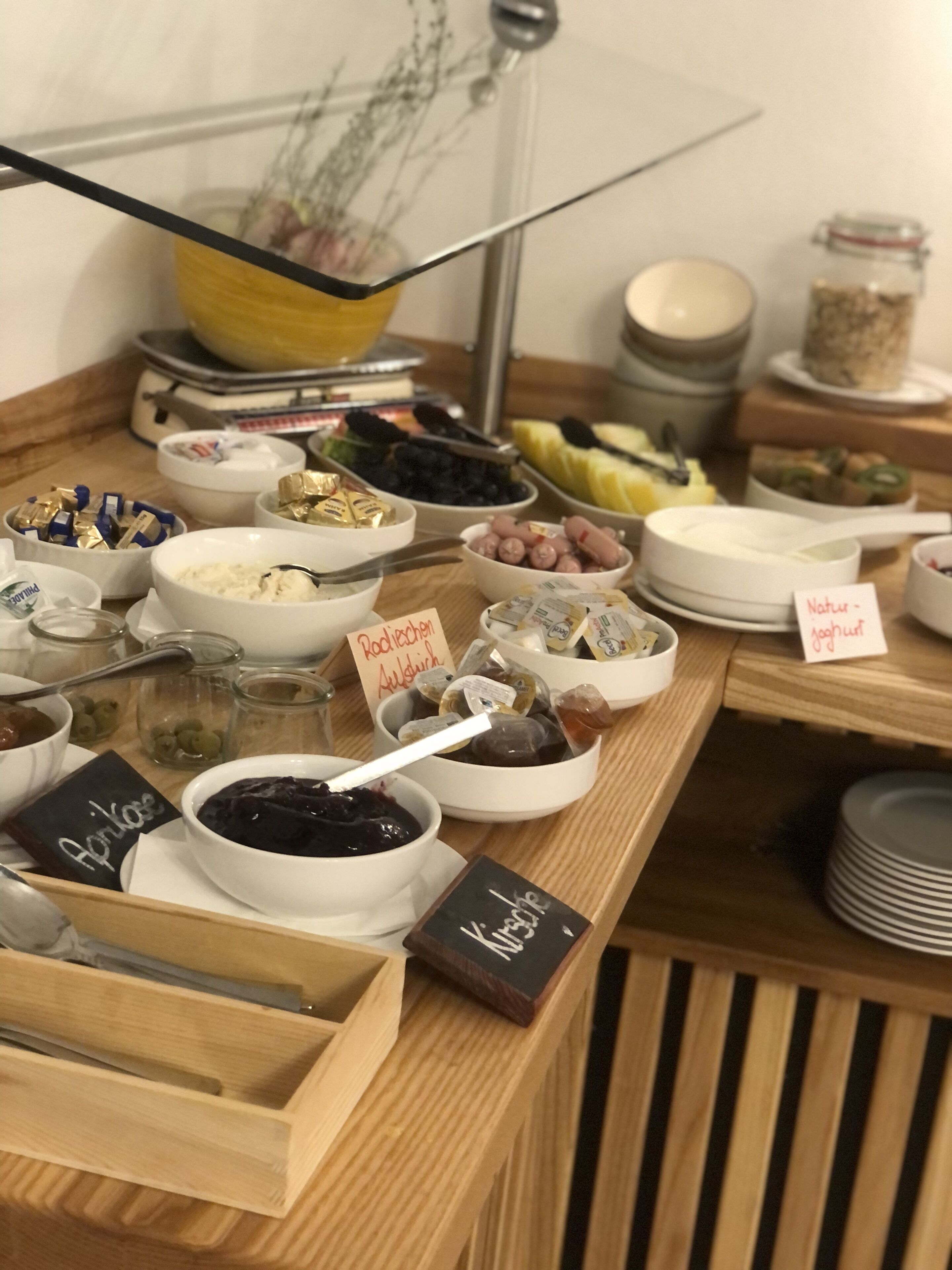 Un bufé con diferentes tipos de comida e indicaciones que describen cada plato.