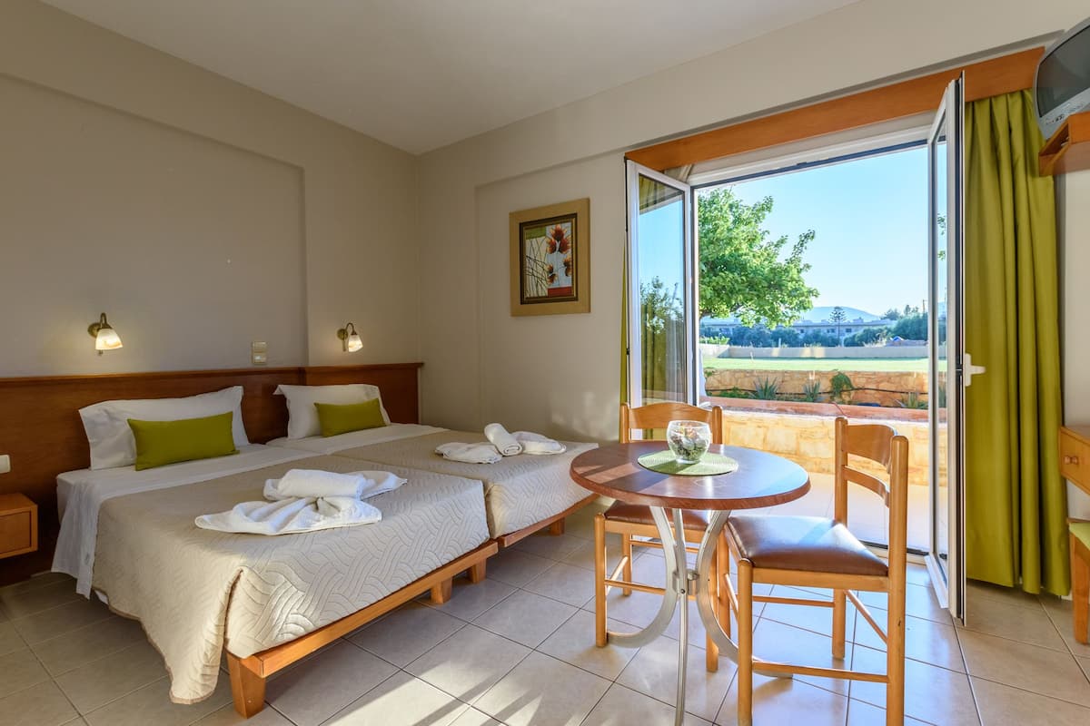 Une chambre d’hôtel avec deux lits, une table à manger et une vue sur l’extérieur.