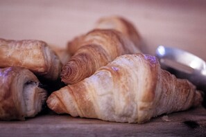 A wooden surface with several croissants.
