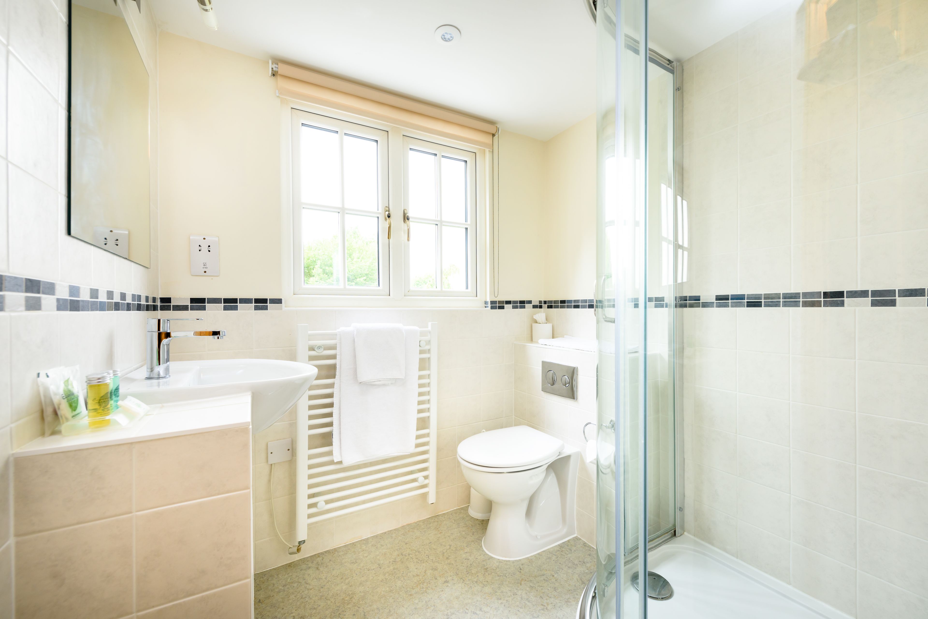 Un baño con lavamanos blanco, inodoro y zona de ducha.