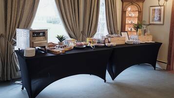 A dining table set with various food items and a tea display.