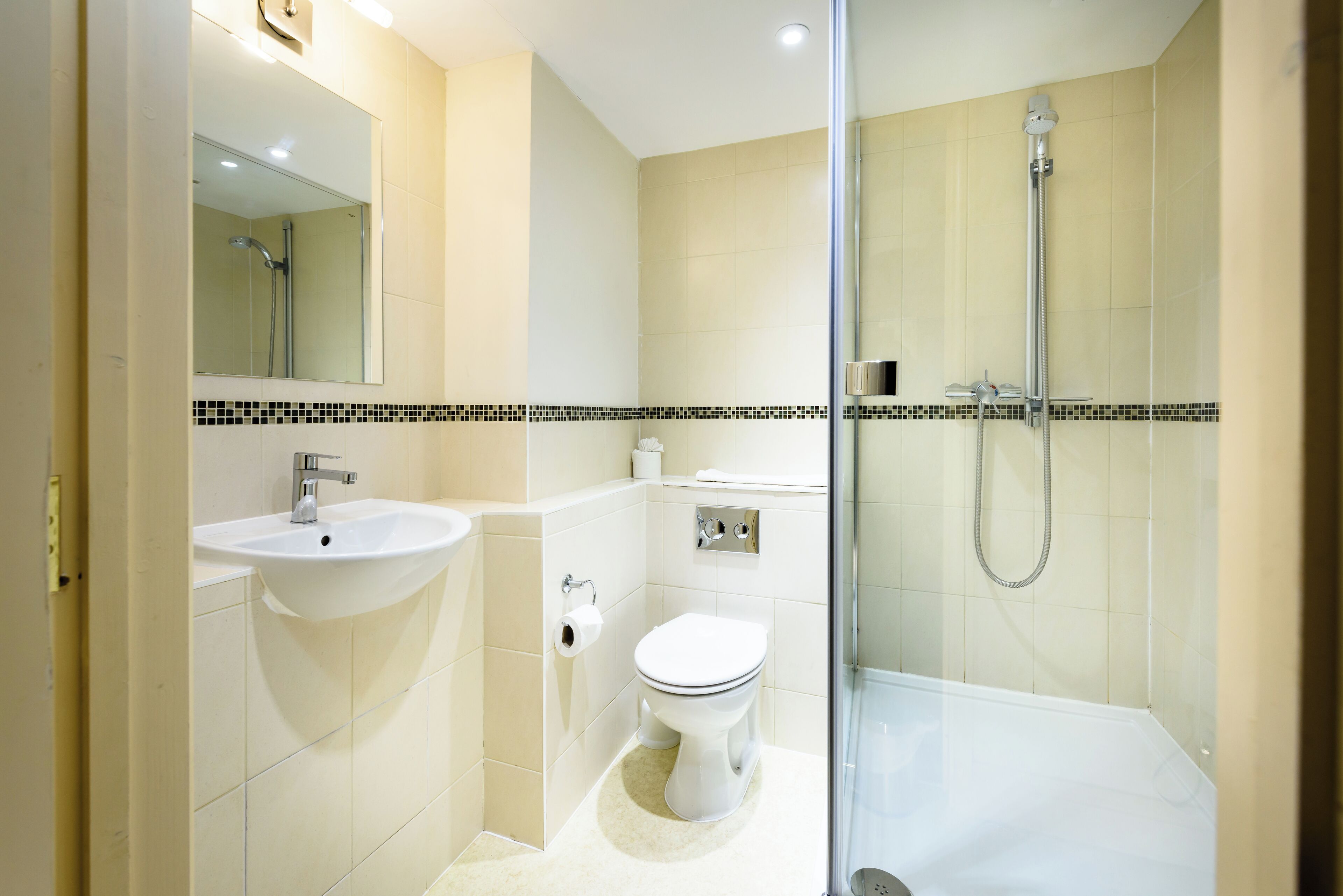 A modern bathroom with a glass-enclosed shower, a sink, and a toilet.