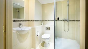 A modern bathroom with a glass-enclosed shower, a sink, and a toilet.