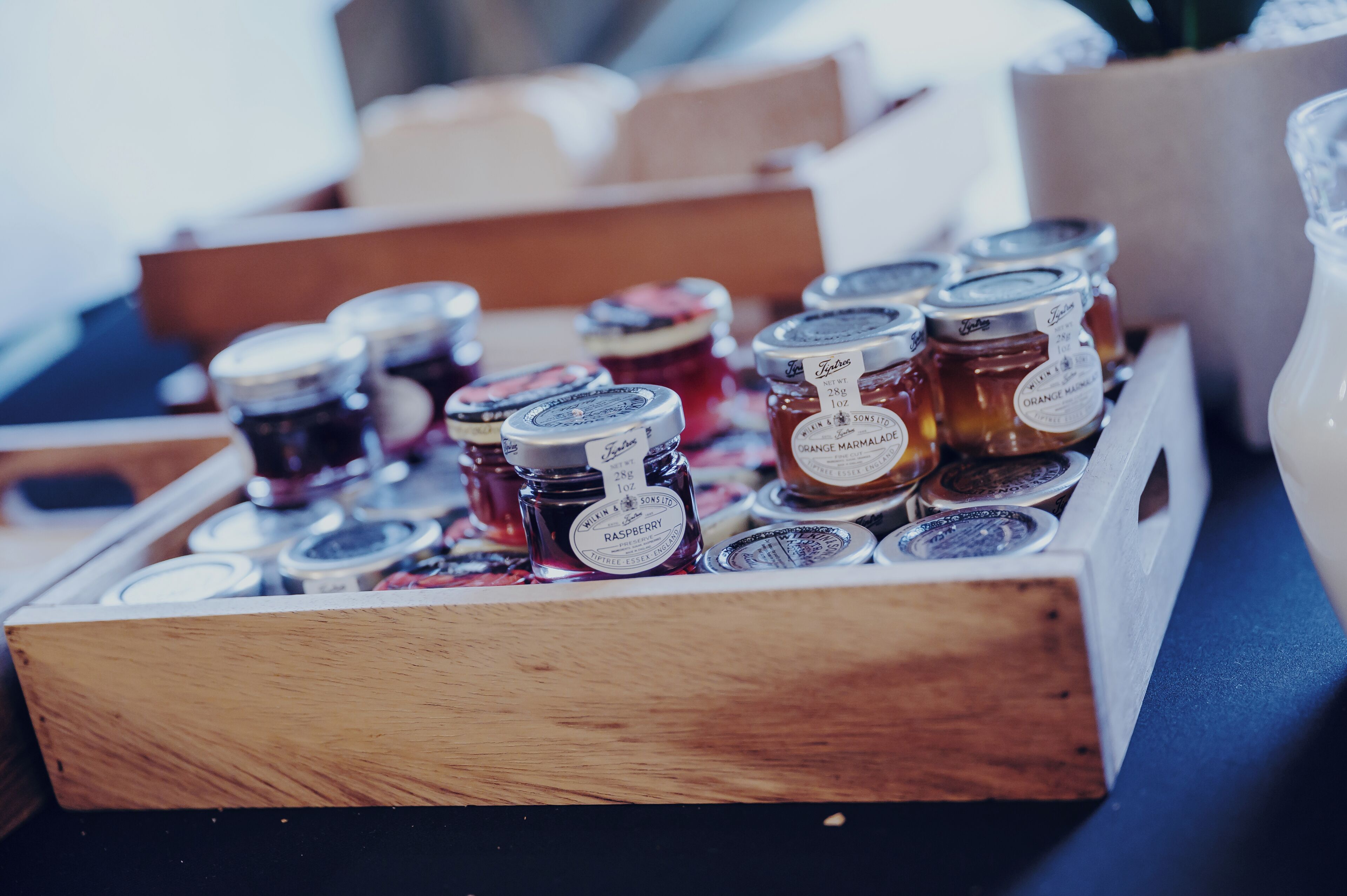 A wooden box containing various jars of marmalade.